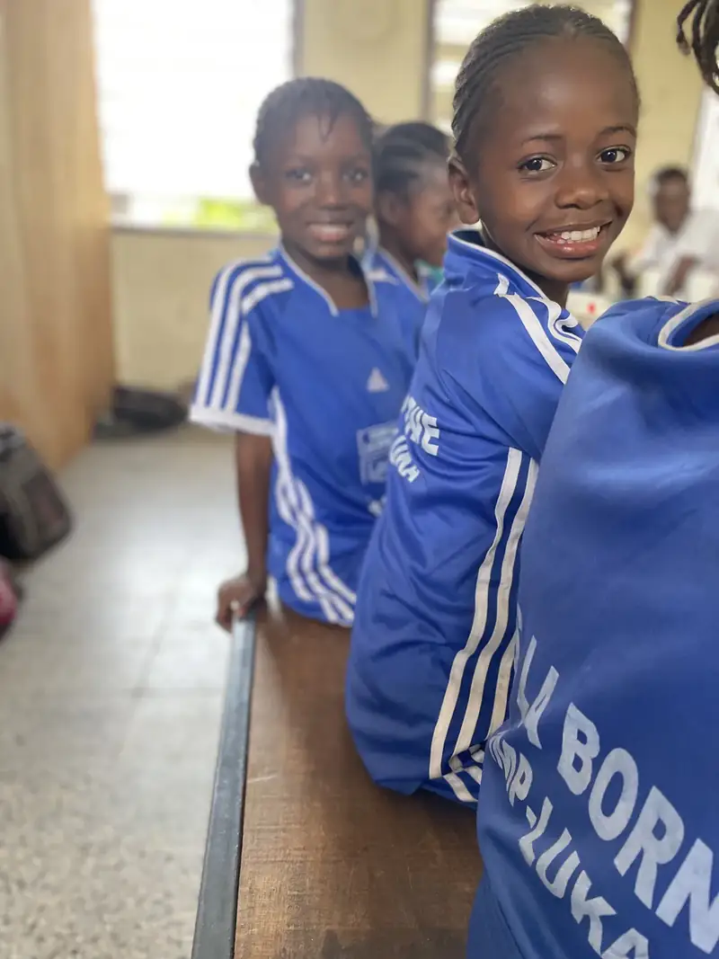 Two girls at a bench at a CarePoint, smiling